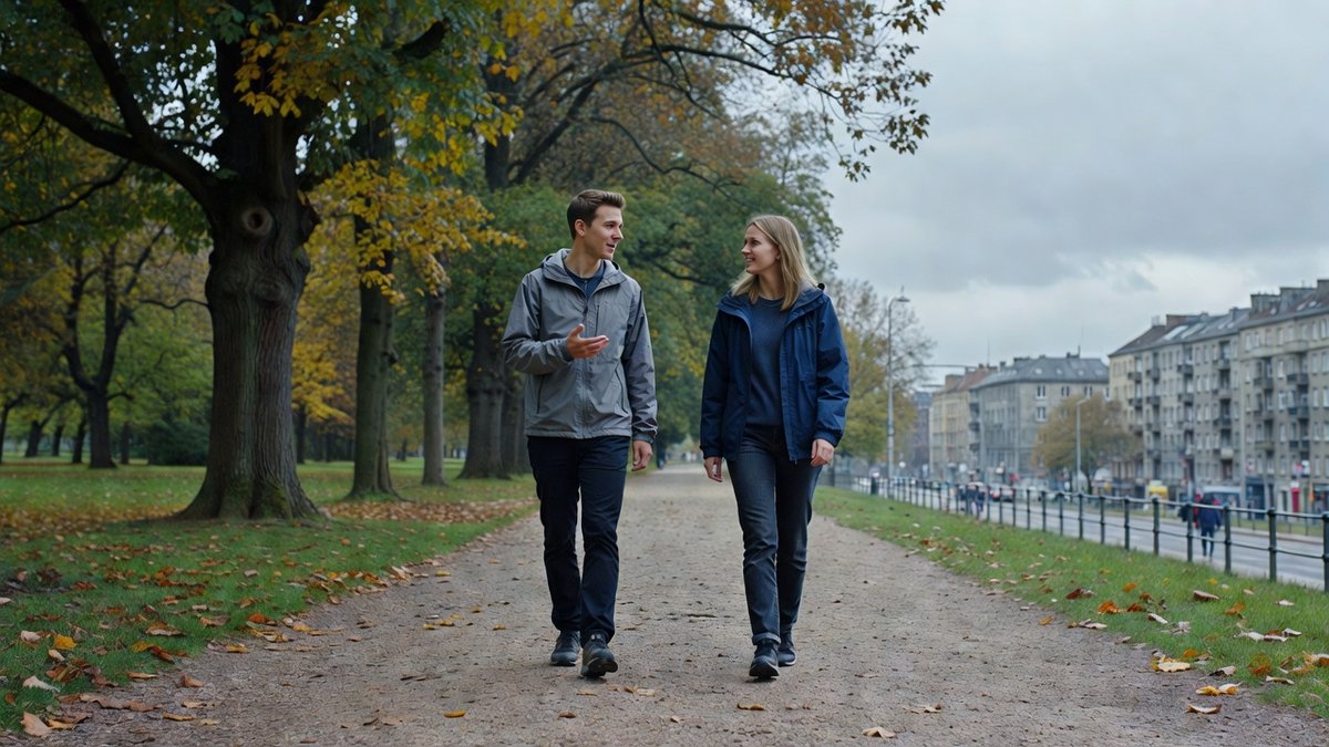 Zwei junge Erwachsene gehen auf einem baumbestandenen Weg und sprechen miteinander (KI-generiert)